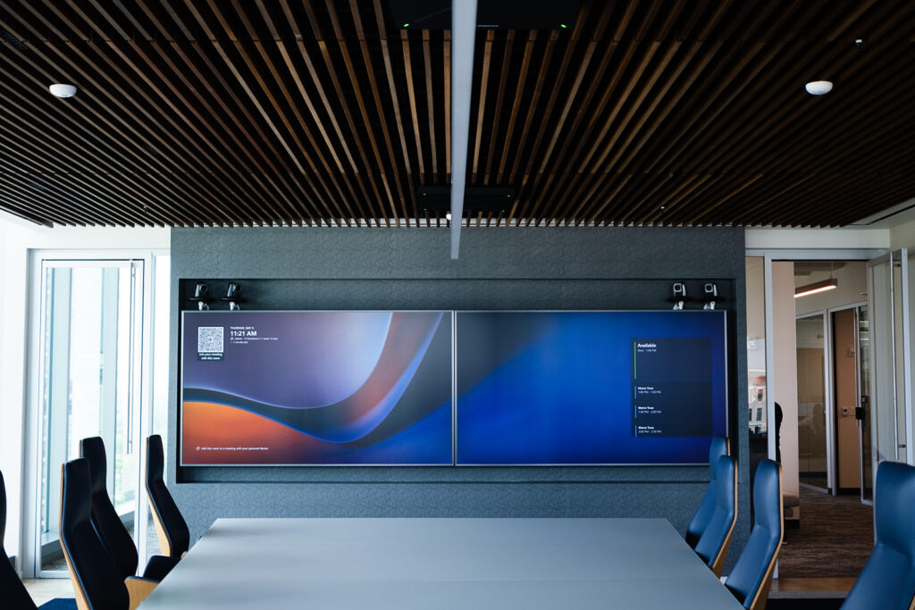 Enterprise conference room with dual displays, ceiling speakers and integrated professional AV systems.